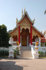 Ornate Buddhist temple in Chiang Mai, Thailand, featuring intricate golden carvings and traditional Lanna-style architecture.