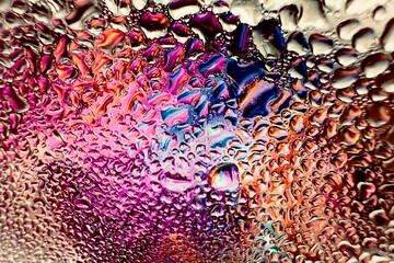 Close-up of water drops on metal surface in high resolution showing condensation of water droplets on metal surface. Intricate patterns and different sized water droplets create a beautiful abstract