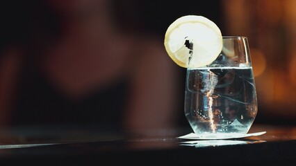 Closeup of gin fizz cocktail garnished slice lemonade serving to customer background on luxury counter bar at nightclub. Special sour drink showcasing elegance nightlife mixology inviting. Vinosity.