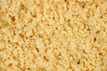A close-up, top-down shot of blended raw soy, showing its coarse texture and pale yellow color