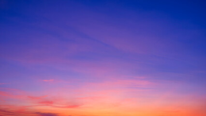 Obraz premium Twilight sky background with pink clouds on colorful orange and blue romantic evening sky after sundown