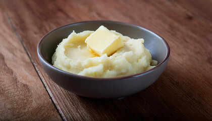 Bowl of mashed potatoes with pat of butter melting. Tasty homemade dish. Delicious food.