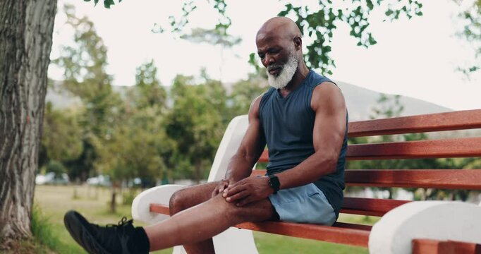 Senior man, knee pain and outdoor fitness for injury, park and check muscle for inflammation on bench. Joint, strain and monitor physical symptoms in nature, black person and sports exercise accident