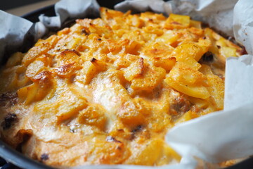 Moussaka is a Balkan oven dish. Potatoes, minced pork, fried onions in layers. Yogurt or sour cream mixed with eggs baked on top. Baking sheet with moussaka on baking paper. Serbian version of cooking
