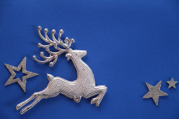 Beautiful Christmas silver deer close up isolated on a blue background. Adorable reindeer with...