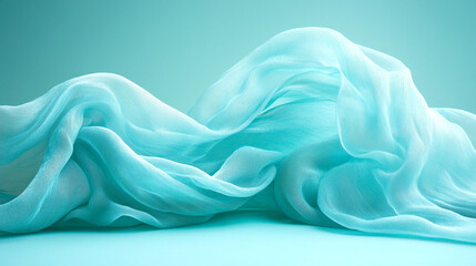 Fototapeta premium Flowing turquoise fabric with soft folds and waves, creating an elegant and airy texture against a matching background.