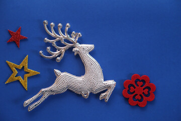Beautiful Christmas silver deer close up isolated on a blue background. Adorable reindeer with...