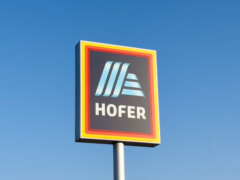 Hofer supermarket sign against a clear blue sky showcasing vibrant colors and modern design, representing retail branding and shopping experience concept