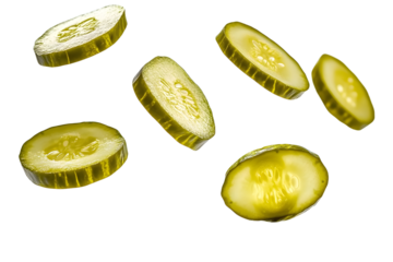 Isolated falling pickled cucumber slices captured on a clean white surface.