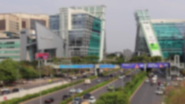 Blurred view of the Raghvendra Marg Road, business center buildings and vehicle traffic in Cyber City, Gurugram, Haryana.