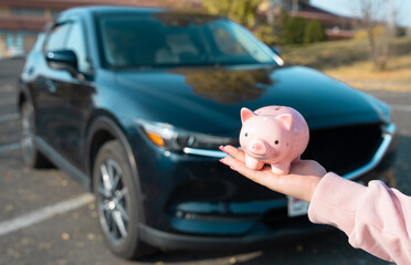 Saving for Dreams: A Driver Holds a Piggy Bank on the Path to Car Ownership
