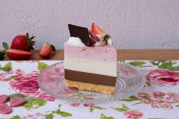 Strawberry, vanilla and chocolate cake decorated with chocolates and strawberries. Neapolitan cake