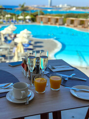 breakfast in the restaurant near the blue pool in the hotel with fresh juice and prosecco .