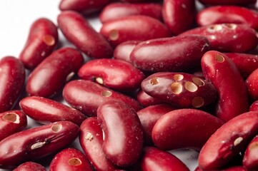 A close-up shot shows the vibrant texture and color of a heap of uncooked kidney beans.
