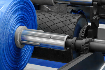 Automatic polyethylene plastic bag production machine. Close-up of roller of plastic bag production...