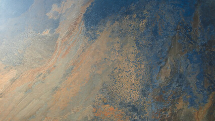 A rocky surface with a blue and brown color scheme. The surface is rough and uneven, giving it a rugged appearance. The blue and brown colors create a sense of depth and contrast