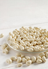 Cashew nuts in milk chocolate on a white wooden background.