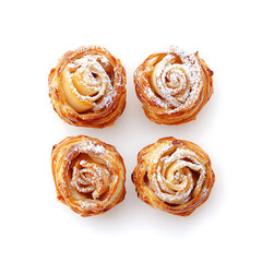 Fototapeta premium Four rose-shaped pastries dusted with powdered sugar arranged on a clean white surface viewed from directly above.