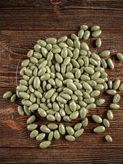 Green chocolates on a brown wooden background. Sweets in a glass plate.