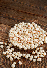 Dried fruits in white milk chocolate. Candies on a brown wooden background.