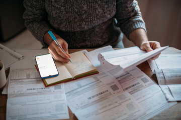 Close-up of men's hands with a calculator and utility bills. The concept of rising prices for...