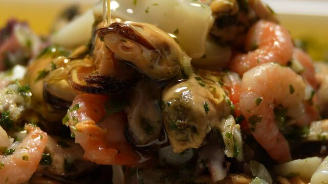 A delicious seafood dish is served on a yellow plate. The dish is a mix of shrimp, clams, and other seafood, all cooked to perfection. The shrimp are placed on top of the shellfish and covered with oi