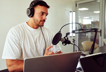 Radio host speaking and taking notes during a live podcast