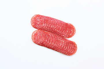 Thinly sliced ​​salami sausage on white background. Top view of tasty sliced ​​sausage. Appetizer