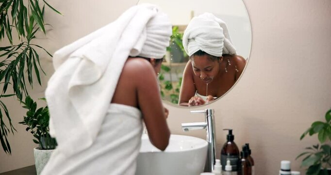 Skincare, woman and washing face in home mirror for morning routine, skin hydration and deep cleansing. Reflection, person and water for cleaning bacteria, dirt removal and beauty glow with towel