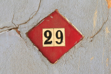 Street address number, number 29. Two yellow-gold tiles with black numbers inset in a single...