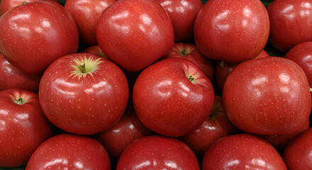A close-up photograph of bright red apples piled together, showcasing their glossy and fresh appearance