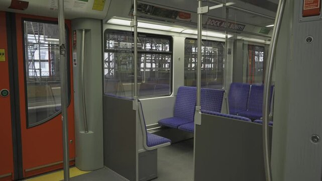 Innenansicht S-Bahn-Wagens ohne Personen in Berlin, Deutschland. S-bahn train coach interior inside with nobody in Berlin, Germany. Empty interior modern train Deutsche Bahn with blue checkered seats 
