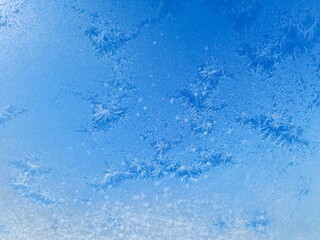 Ice crystals creating beautiful frozen patterns on window in winter
