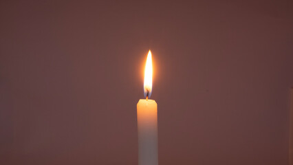 A candle burning on a dim background