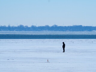 Ice fishing on frozen lake