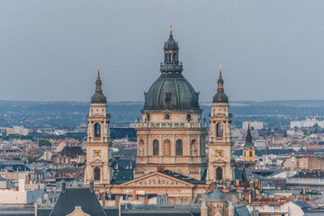 view of cathedral church hungarian catholic with big bell towers in front and dome over the city skyline