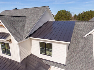 Obraz premium Sunny Daytime Drone Images of a Custom Home in the Final Stages of Construction. It Features a Roof With Architectural Asphalt Shingles and Standing Seam Accents. 