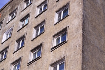 A modern cityscape featuring a tall building with numerous windows and a prominent clock tower.