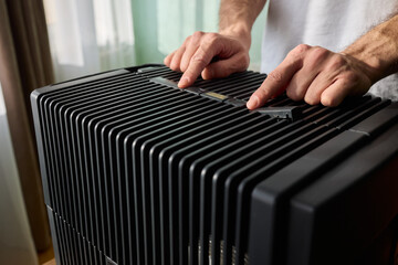 Hands adjusting a modern appliances control panel for optimal functionality and home comfort
