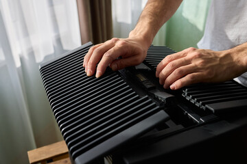 A person diligently assembling a contemporary black cooling device with precision and focus