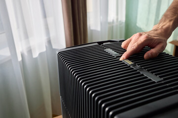Hands adjusting a modern appliances control panel for optimal functionality and home comfort