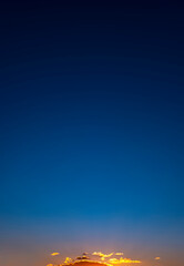 Obraz premium Sky clouds sunset natural background. Stunning view of golden clouds and gradient blue sky