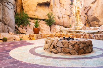Outdoor stone firepit surrounded by rock mountains in Mexico.