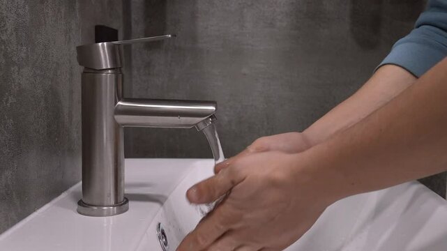 Hand washing process, hands include water in faucets and thorough cleansing technique with running water, foaming hands, rinsing and removing excess moisture in clean bathroom
