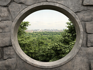 View of a lush green landscape framed by circular stone structure overlooking a city skyline in daylight