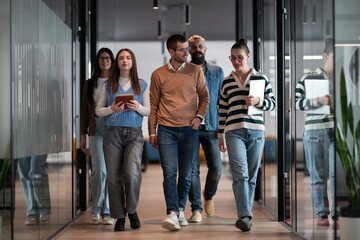 Business team in a modern open space startup office walking together. Diverse group of...
