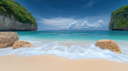 Obraz premium Tropical beach waves crashing on sand, limestone cliffs, azure water, blue sky