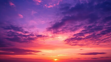 Obraz premium Dramatic sunset sky with red, purple, and orange hues blending seamlessly over soft clouds