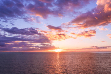 The sun to set over the horizon reflected in the sea