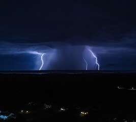 Multiple lightning bolts at night with downburst of rain in mthe iddle